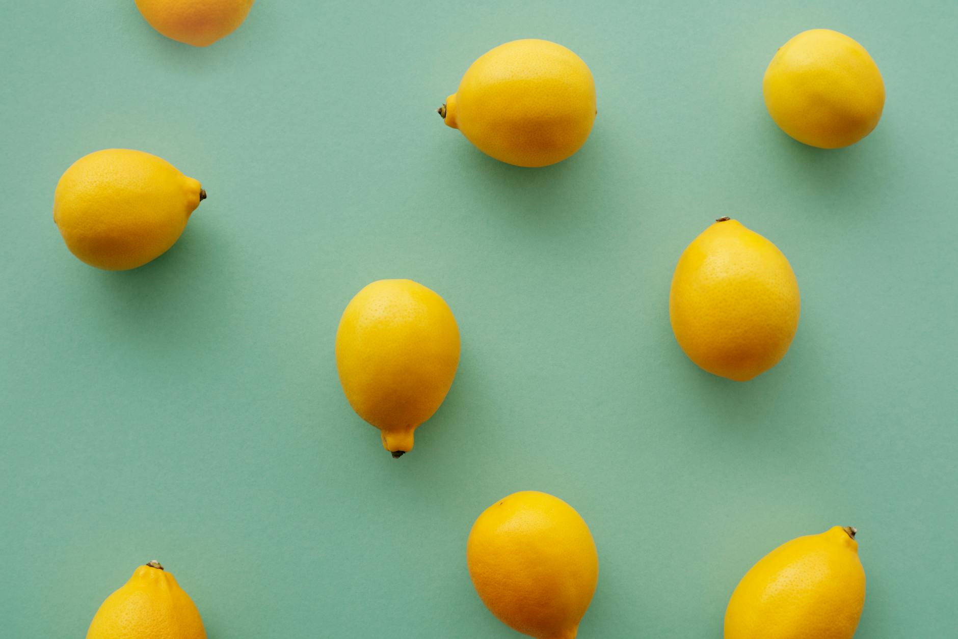 Hand holding a fresh lemon against a bright yellow background, symbolizing renewal and self-care after life transitions