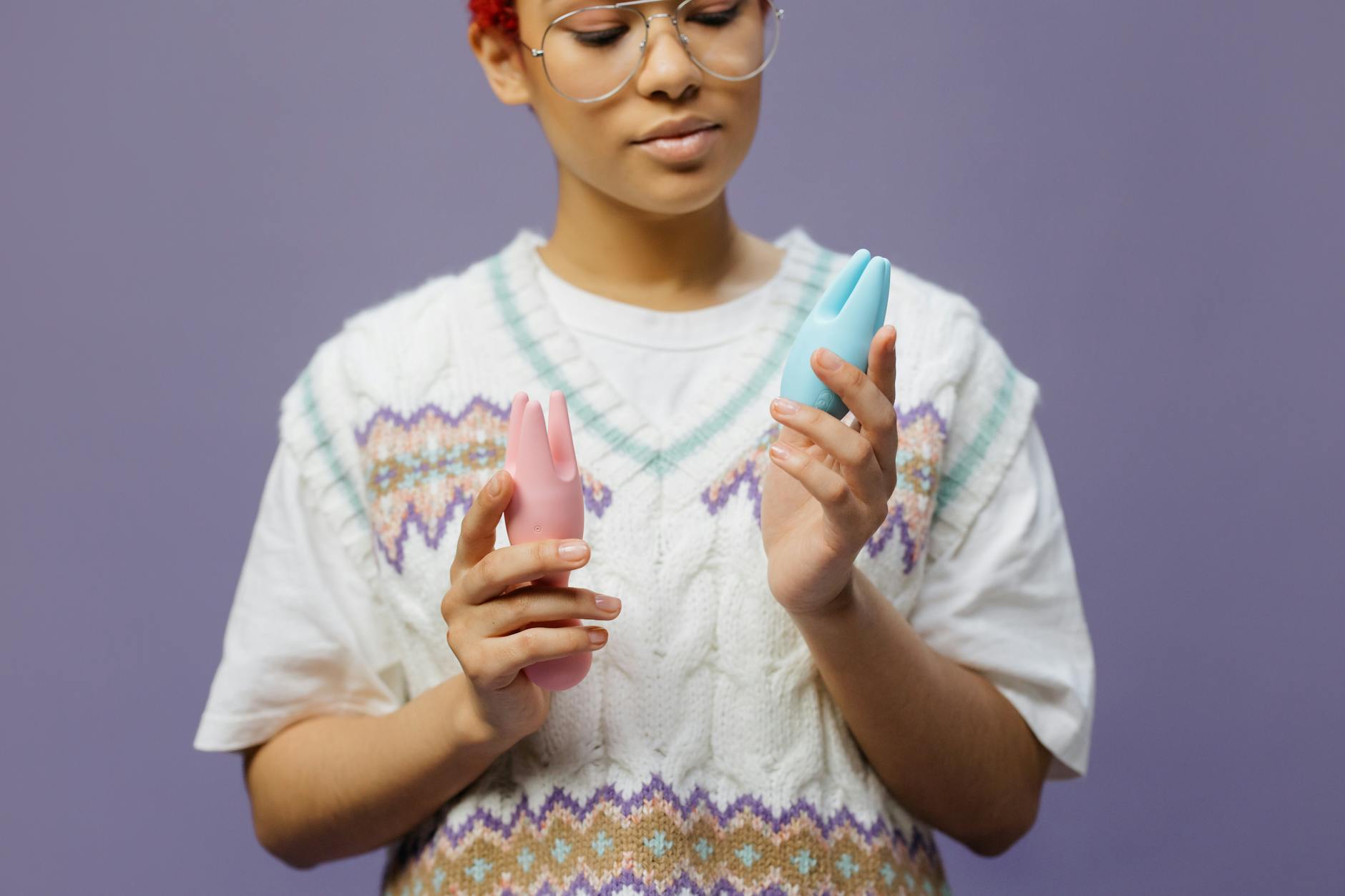 Hand holding a vibrator against a minimalist backdrop, representing modern couple pleasure.