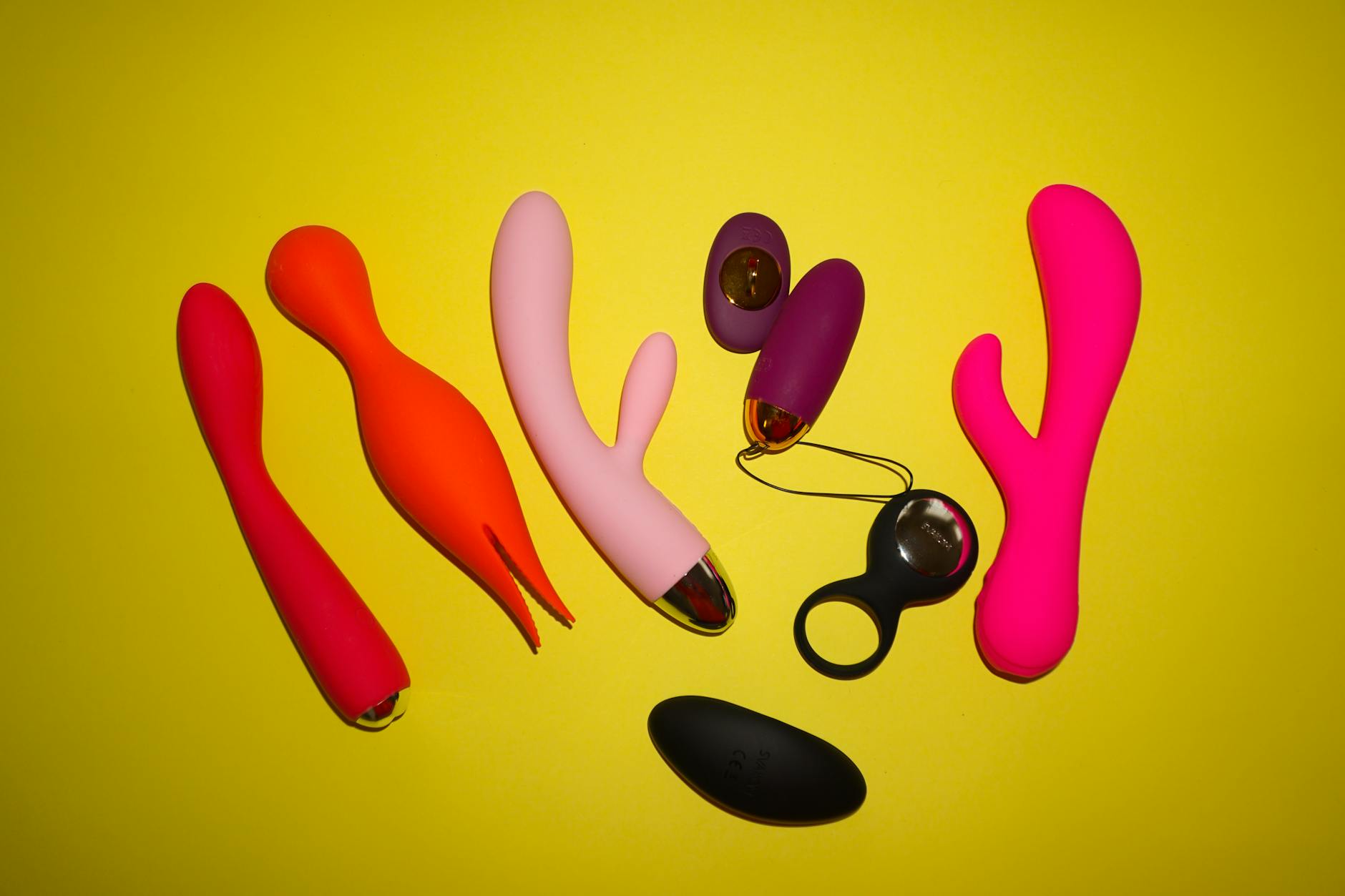 A person holding a basket containing colorful vibrators and a pink flower